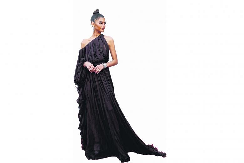 The Greatest Showman star Zendaya is positively regal in a draped Giambattista Valli Couture chiffon goddess gown. The deep chocolate brown colour looks beautiful against her caramel skin and the unusual asymmetrical sleeves give the dress an interesting 