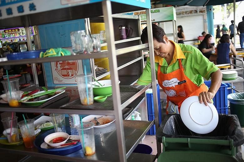 At Zion Riverside Food Centre, cleaners' aprons carry messages reminding patrons to return their food trays. The daily return rate improved four months after these reminders were introduced around the food centre.