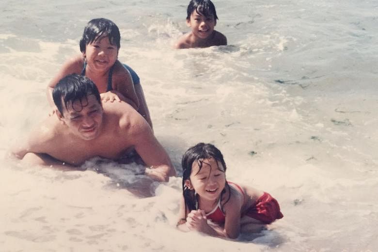 Ms Chan behind her father, former regional sales director Henry Chan, with her two siblings in happier times.