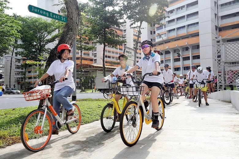 Grassroots leaders cycling with residents in Jurong East last April. In Parliament yesterday, Mr Chan Chun Sing said government agencies, including grassroots organisations under the PA, would work with both grassroots advisers and opposition MPs "on