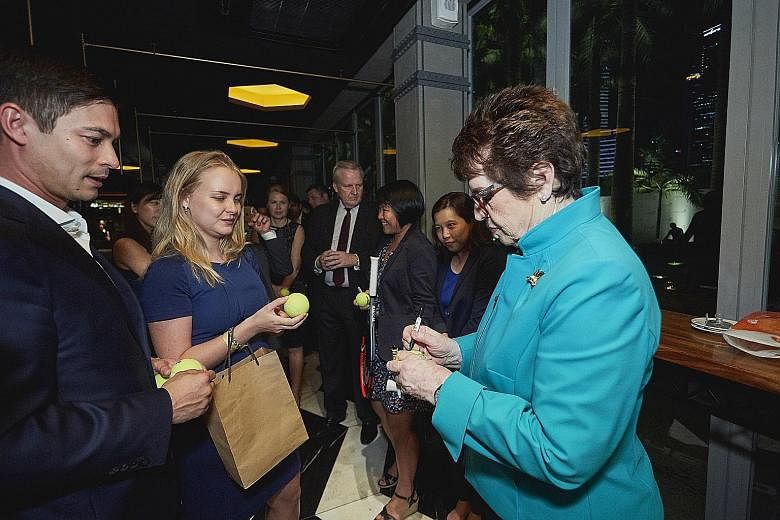Ian Pryor, managing partner at IPP Financial Advisers, a returning customer of the Racquet Club - the WTA Finals hospitality programme - looking on as Billie Jean King signs tennis balls for guests on Thursday. They were at Marina Bay Sands where eve