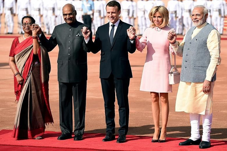 (From left) Mrs Savita Kovind, her husband and Indian President Ram Nath Kovind, French President Emmanuel Macron, his wife Brigitte and Indian Prime Minister Narendra Modi at a ceremonial reception at the Indian Presidential Palace in New Delhi yest