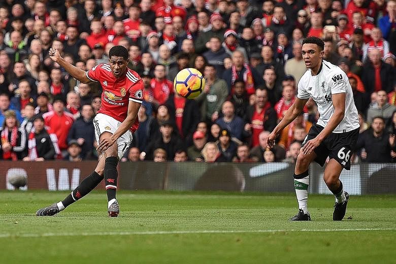 Manchester United's English striker Marcus Rashford scoring the opening goal against Liverpool, with defender Trent Alexander-Arnold powerless to stop him, in their English Premier League match at Old Trafford. United's 2-1 win boosts their chances o