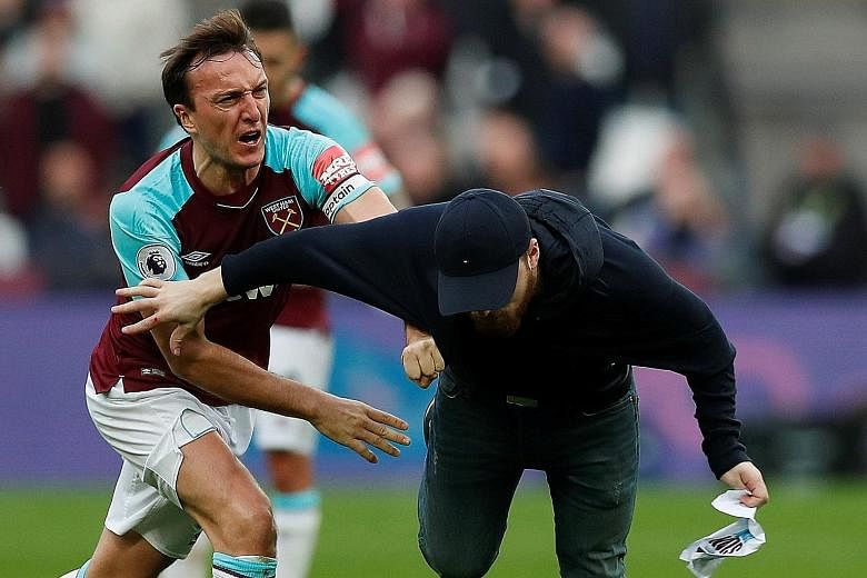 West Ham skipper Mark Noble clashes with a fan who invaded the pitch on Saturday. Noble told British media that tensions have been rising among the club's supporters since the switch from Upton Park.