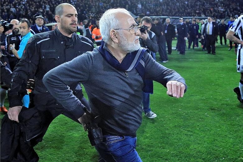 Ivan Savvides, Russian-born Greek businessman and owner of Paok Salonika, carrying what appeared to be a gun in a holster. He entered the pitch accompanied by bodyguards after the referee disallowed a goal by his side against AEK Athens, whose player