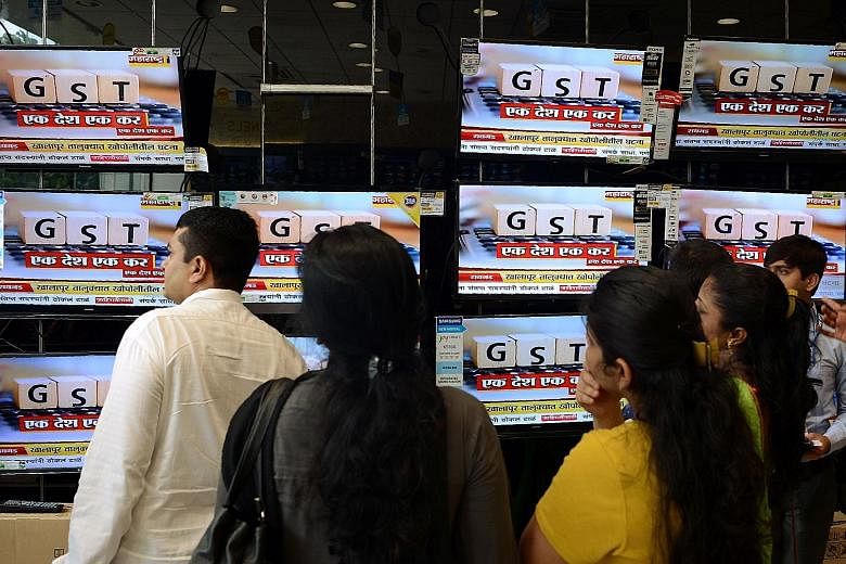 News on the new GST regime being reported on TV in Mumbai last June. Even though the GST has simplified a complex system of multiple federal and state taxes, eight months into its launch, it is still plagued by issues like online portal glitches and 