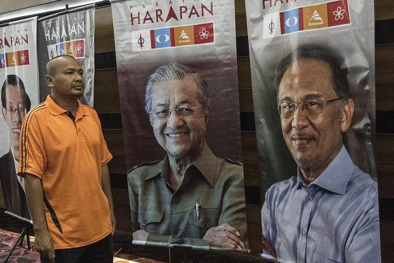 Posters of Anwar Ibrahim (right) and Dr Mahathir Mohamad in Shah Alam. Dr Mahathir says he made the wrong decision to go strictly by the book and sack Anwar, who was deputy prime minister and finance minister.