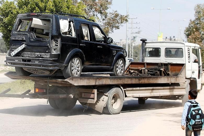 A damaged vehicle from the Palestinian Prime Minister's convoy being taken away yesterday after the attack near the Gaza Strip's northern town of Beit Hanoun. Palestinian Prime Minister Rami Hamdallah waving to the crowd upon his arrival in the West 