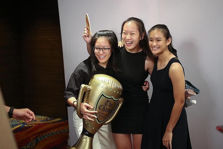 From top: The ST Young Athlete of the Year Justin Hui with his trophy. Wang Jinghan (centre), formerly from Nanyang Girls' High School, nominated for her judo exploits, having fun at the photo booth with friends. Minister for Culture, Community and Y