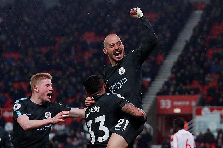 Manchester City's David Silva celebrating his second strike with the creator of the goal Gabriel Jesus, and Kevin de Bruyne. The Spaniard's double sealed three points on a cold, rainy night in Stoke as City moved closer to clinching the Premier Leagu