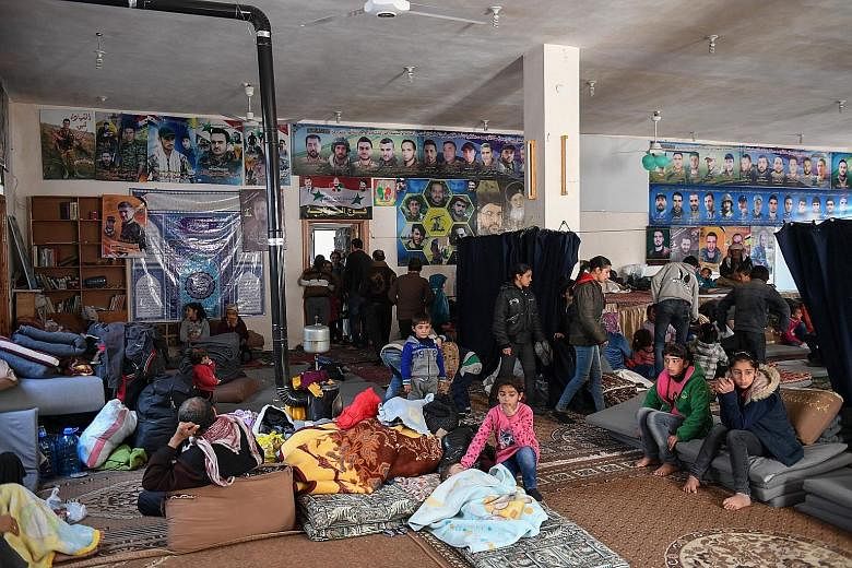 People fleeing the Turkish offensive on the Syrian Kurdish town of Afrin taking refuge in a shelter in Nubol, 26km north-west of Aleppo, yesterday. Analysts suggest Turkey will be content to lay siege to Afrin for some time while allowing civilians t