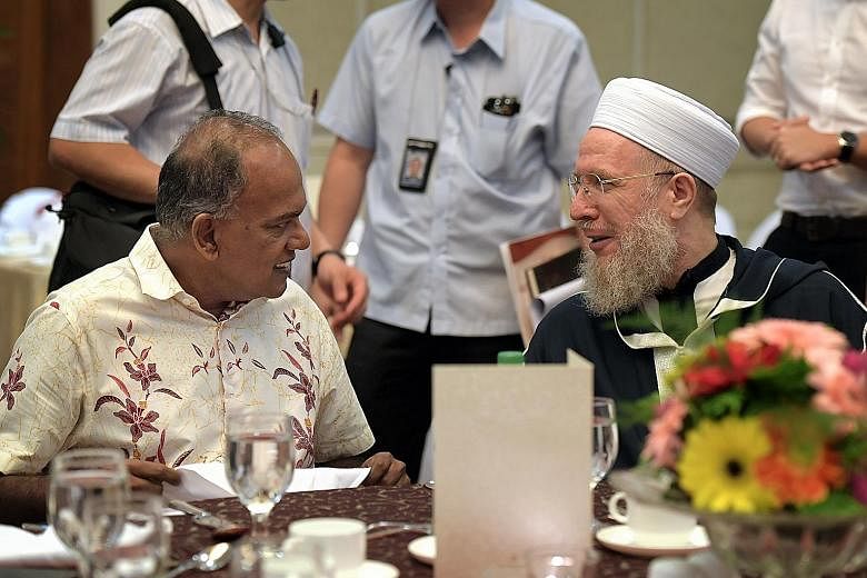 Home Affairs Minister K. Shanmugam speaking with Syrian Islamic scholar Shaykh Sayyid Muhammad Al-Yaqoubi at the Religious Rehabilitation Group's 14th Annual Retreat yesterday.