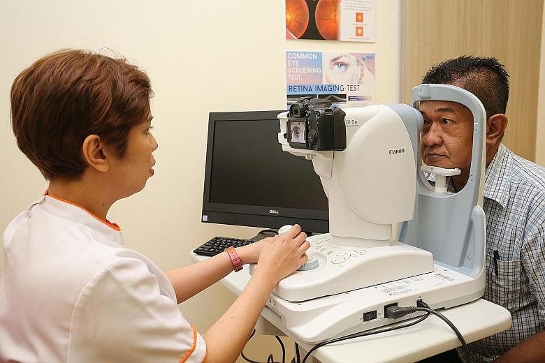 NUH senior enrolled nurse Nurhidah Afendi performing a diabetic retinal photography service for Mr Abdul Razak Abdul Rahman at Keat Hong Family Medicine Clinic. The 58-year-old diabetes patient said he finds the clinic more convenient than polyclinic