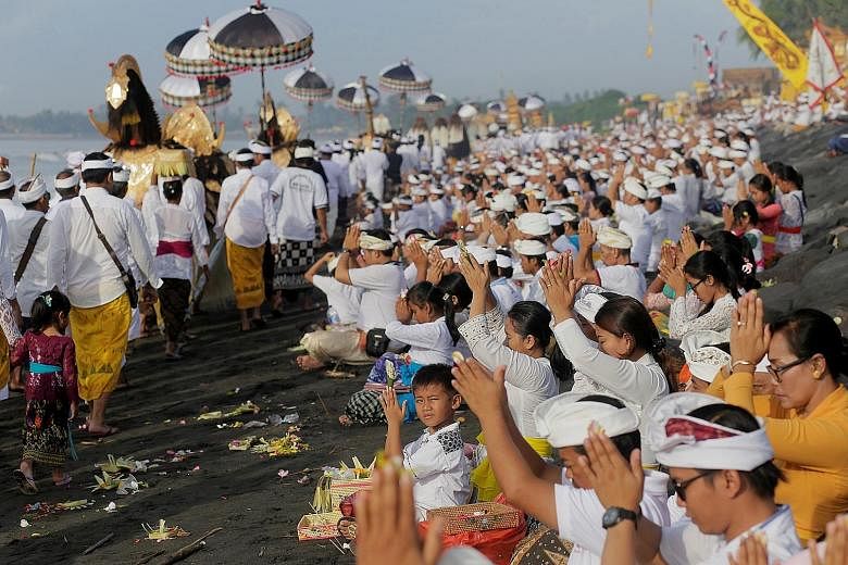 Hindus praying on a Bali beach yesterday during a purification ceremony ahead of the holy day of Nyepi. The Indonesian tourist island falls silent during the annual observance of Nyepi, the religious holiday which marks the Balinese new year. Islande