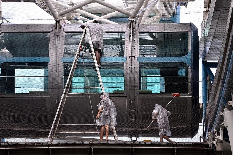 Above: Workers taking the opportunity to clean a capsule during the Singapore Flyer's downtime on Wednesday. Operations at the Flyer have been suspended since Jan 25 due to "technical issues". Left: Tenants say visitor numbers have dropped drasticall