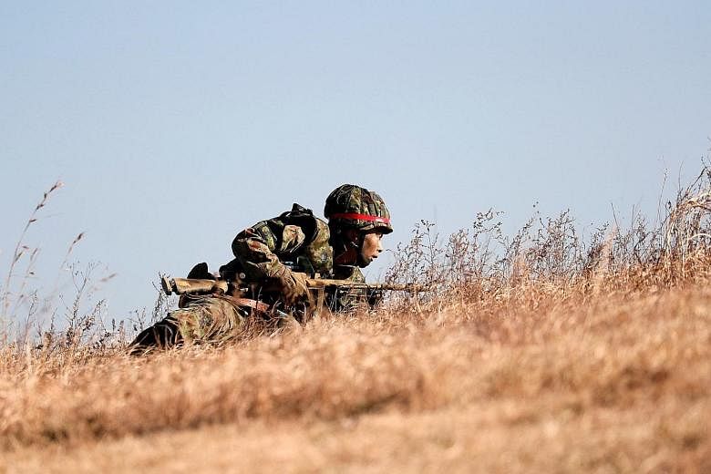 A member of Japan's Ground Self-Defence Force taking part in an annual new year military exercise in Funabashi, east of Tokyo, in January. Japanese Premier Shinzo Abe wants to insert an explicit reference to the Self-Defence Forces in Article 9 of th