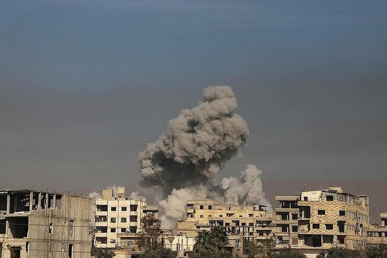 Smoke billowing in Hazeh in the beleaguered rebel enclave of Eastern Ghouta on the outskirts of Damascus yesterday. The Syrian Observatory for Human Rights said the town of Hammuriyeh in the enclave fell to regime forces after Islamist rebels from Fa