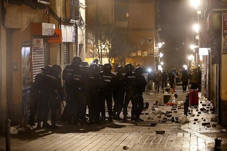 Spanish riot police facing off against protesters during a violent demonstration in Madrid on Thursday night. The protesters were angry over the death of a Senegalese street vendor who they said was chased through the streets by police. They set fire