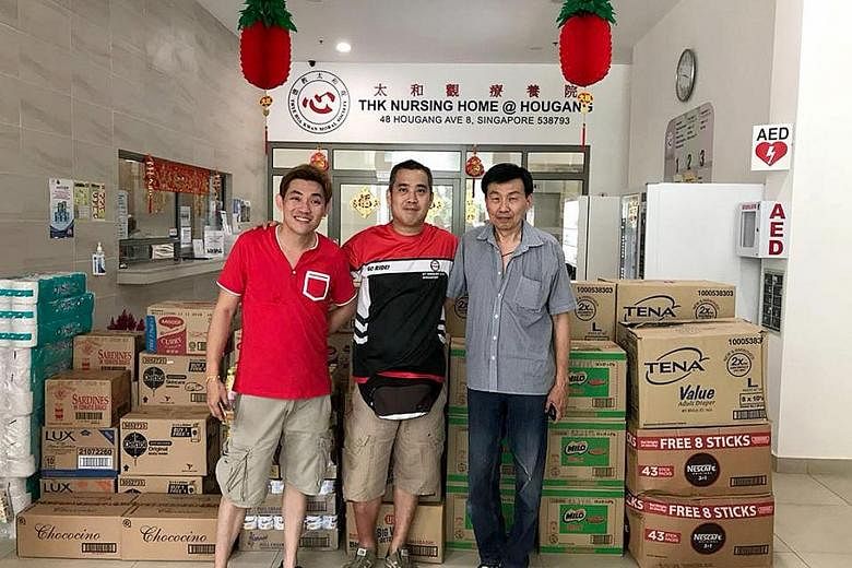 Taxi drivers (from left) Patrick Tan, Admen Lim and Albert Khoo, with the donated goods at the Thye Hua Kwan Nursing Home.