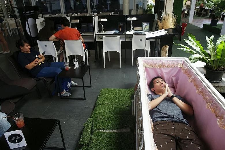 Thai customer Thanawit Suthapanya, 24, prays as he lies inside a coffin in Kid Mai Death Cafe (Rethink Death Cafe) in Bangkok, and no wonder, because he might as well be at his own funeral. The experience he had yesterday was a strange and eerie one,
