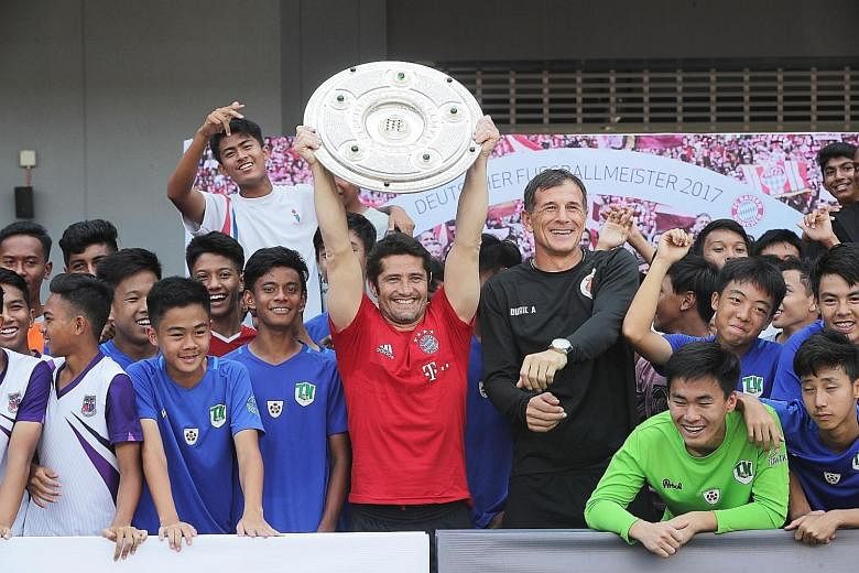 Bixente Lizarazu lifting the Bundesliga Champions Shield, won by his former team Bayern Munich for the past five seasons, alongside principal of the ActiveSG Football Academy Aleksandar Duric and participants of the FC Bayern Youth Cup Singapore. Wat