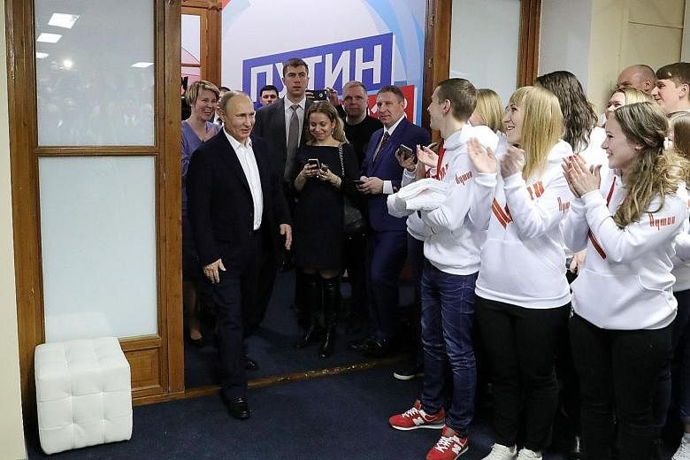 President Vladimir Putin visiting his campaign headquarters in Moscow late on Sunday after his win. He recorded his best-ever election performance with 76.67 per cent of the vote, but rejected the possibility of staying in power indefinitely.