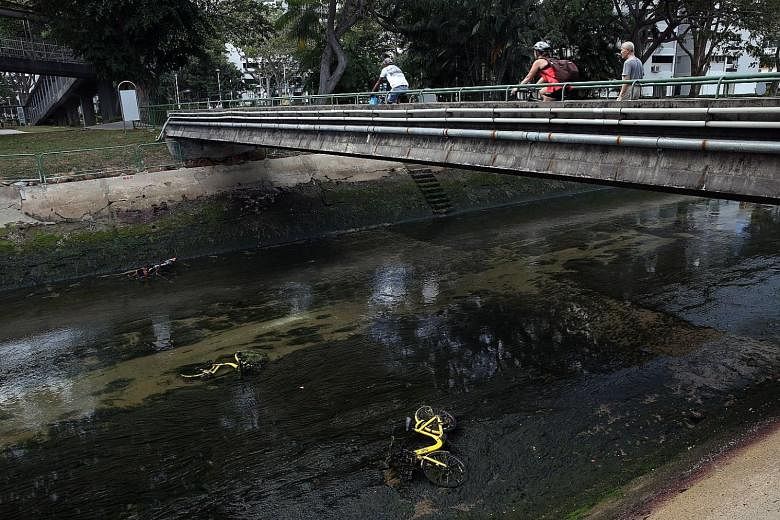 Three shared bikes lying in a canal in Marine Terrace on Monday. Under new rules, users cannot end their rental sessions until their bikes are returned to designated zones.