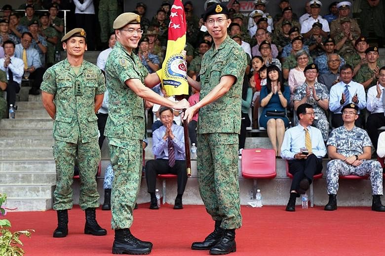 Major-General Melvyn Ong Su Kiat (centre) handing over the command symbol to Brigadier-General Goh Si Hou at a ceremony at Pasir Laba Camp yesterday. BG Goh takes over as Chief of Army from MG Ong, who had held the position since 2016. BG Goh, 40, pr