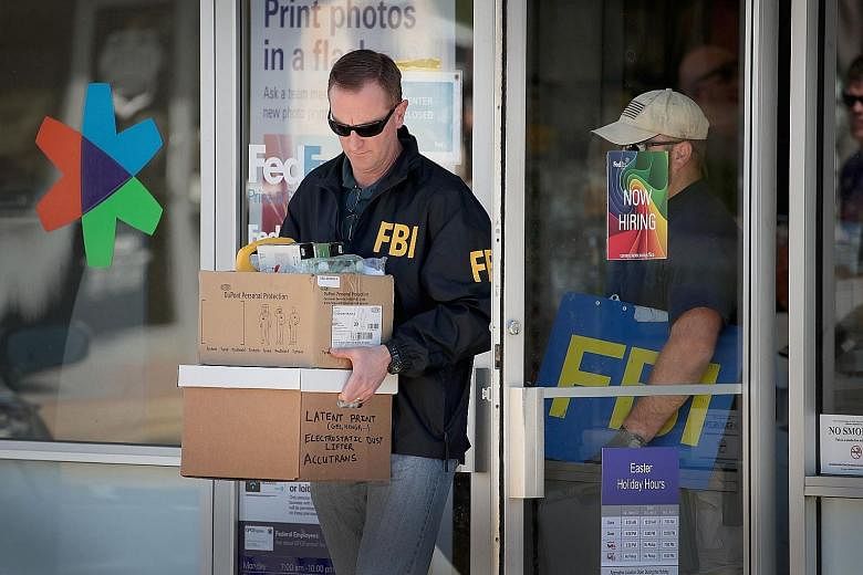 An FBI agent collecting evidence after an explosion at a FedEx sorting facility near San Antonio, Texas, on Tuesday. Emergency responders at the scene where bombing suspect Mark Anthony Conditt killed himself by detonating a device in his car, while 