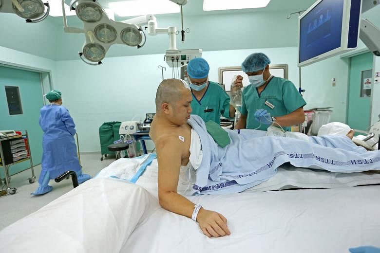 Associate Professor See asking Mr Oh to raise his right arm to test his movement. Awake brain surgery is done in less than 10 per cent of brain tumour cases at the institute, when surgeons need to operate on an area of the brain that involves or is c