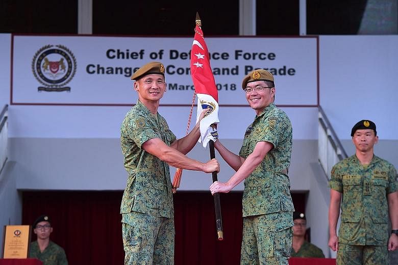 Former army chief Major-General Melvyn Ong Su Kiat yesterday (centre, right) took over as Chief of Defence Force, at a Change of Command Parade held at the Safti Military Institute. Maj-Gen Ong, 43, received the command symbol from the outgoing Chief