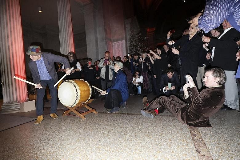 Director Wes Anderson plays photographer as actor Bill Murray hits the taiko drums at the reception for the New York premiere of Anderson's film, Isle Of Dogs, at the Metropolitan Museum of Art in New York on Tuesday.