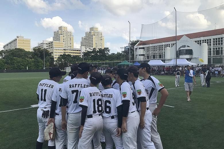 Raffles Institution's softball players, seen here in a team huddle yesterday, beat defending champions Catholic High School 6-4 in the B Division boys' final on home turf.