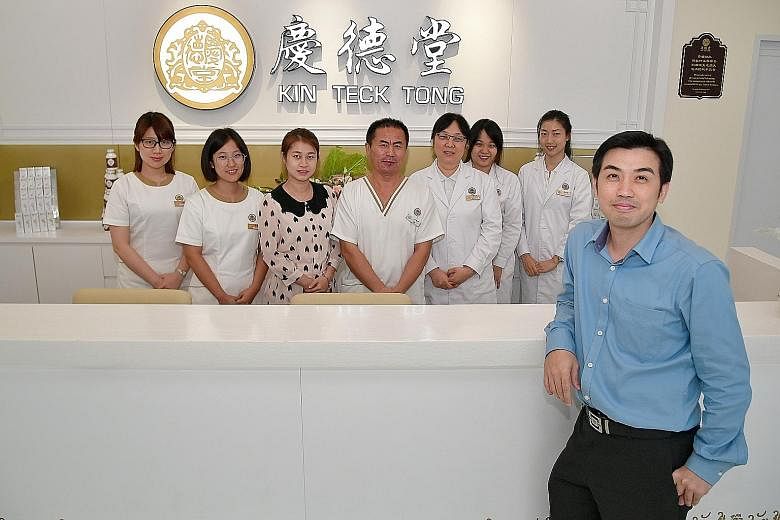 TCM centre Kin Teck Tong's chief operating officer Tan Lip Hong (in blue shirt) with (from far left) receptionists Annie Wong and Winnie Wong; brand operations manager Lydia Liu; therapist Lee Ai Guo; and physicians Yang Ling, Sheryl Teo and Zhang Ya