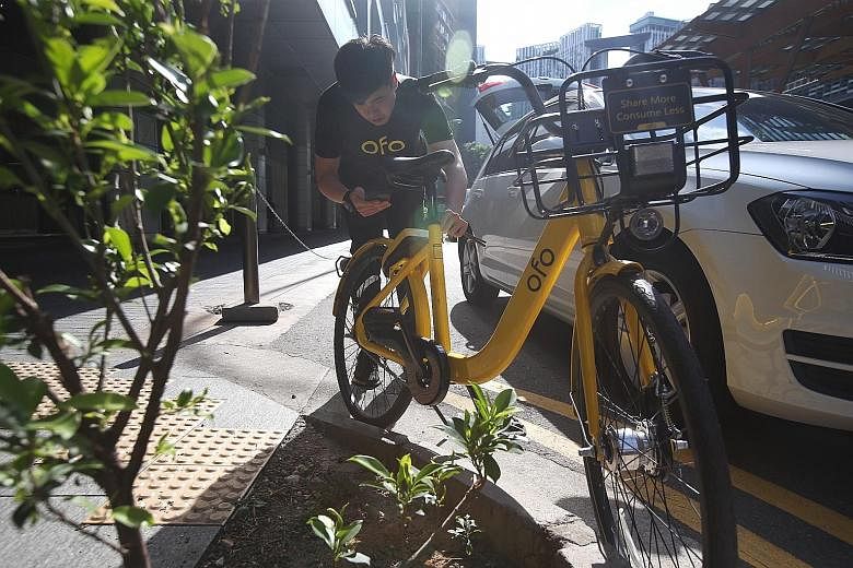 Mr Nicholas Chen, an operations team leader at ofo, unlocking one of the firm's bikes to move it to an approved bicycle-parking space. Doing a marshal's work often means travelling a distance of 50km to 60km a day, said Mr Chen.