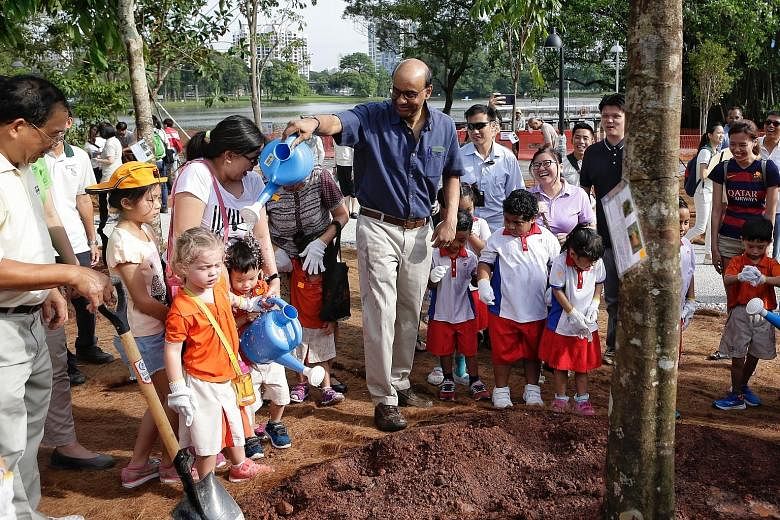 Deputy Prime Minister Tharman Shanmugaratnam having some fun with children during a tree planting activity at Jurong Lake Gardens West yesterday. The western segment of the new gardens will open early next year, with other parts to follow.