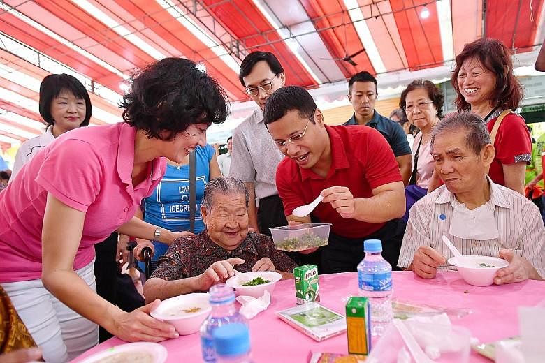 MP for Tanjong Pagar GRC Joan Pereira and Minister for Social and Family Development Desmond Lee serving porridge to Madam Wan Lau Lui, 93, and her friends at Bukit Merah View Square yesterday, as part of the Hot, Happy & Healthy Meal project to help