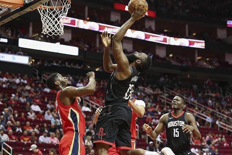 Houston guard James Harden going for a shot as New Orleans guard DeAndre Liggins defends at the Toyota Centre. The Rockets' 59th win beat the previous regular-season mark set in their 1994 championship year.