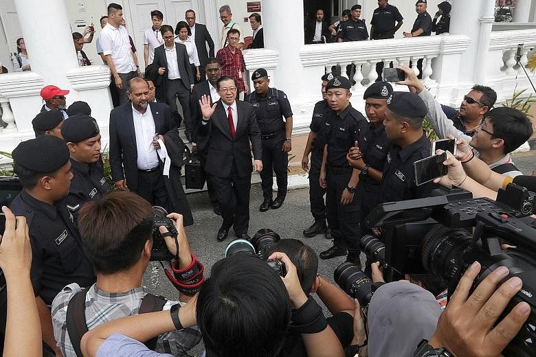 Left: Lim Guan Eng (in red tie) outside the High Court yesterday. Above: Businesswoman Phang Li Koon is charged with abetting Lim in obtaining a bungalow at below market price.