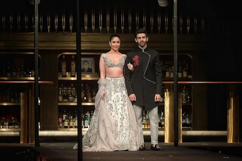 Indian designer Manish Malhotra's first full-fledged fashion show in Singapore features bridal wear modelled by a cast of about 30, including Bollywood celebrities Kareena Kapoor and Kartik Aaryan .