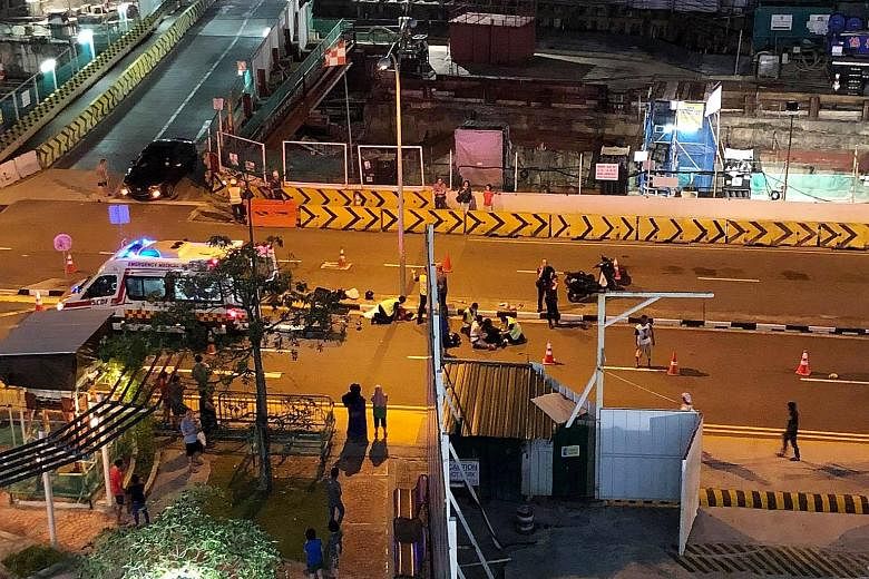 Foreign construction workers directing traffic after an accident involving a car and a motorcycle in Ang Mo Kio Avenue 4 last Saturday night.