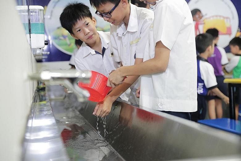 Kuo Chuan Presbyterian Primary School pupils coping without tap water, as part of a water-rationing exercise.