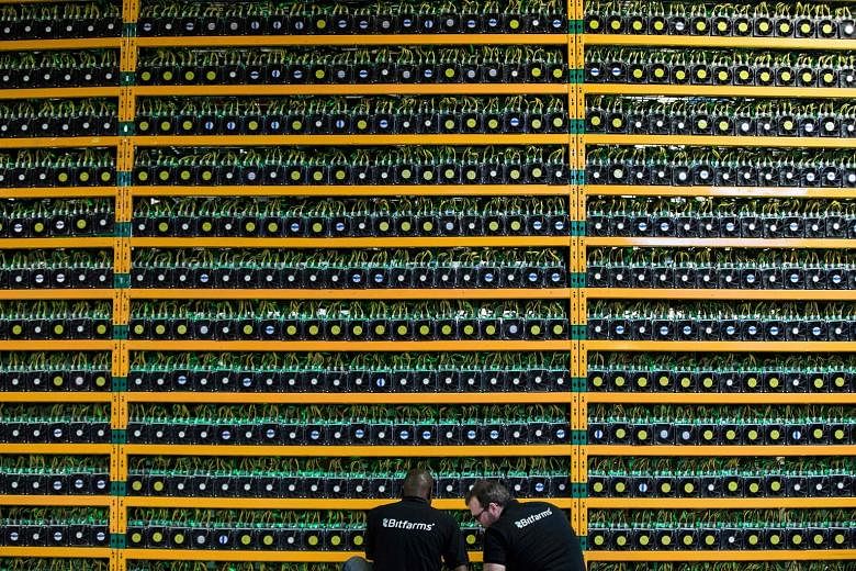 Technicians inspecting bitcoin mining at Bitfarms in Quebec, Canada. Bitcoin is independent of governments and banks and uses blockchain technology, where encrypted digital coins are created by supercomputers.