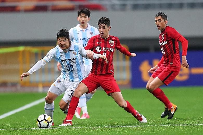 Shanghai SIPG's Brazilian star Oscar (centre) being challenged by Ulsan Hyundai's Park Joo Ho during their AFC Champions League group stage match at home on March 7. The elite Asian club competition is part of the Asian Football Confederation's stabl