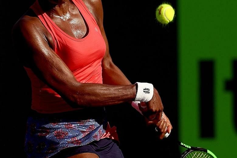 Venus Williams returning a shot during her defeat of Johanna Konta at the Miami Open in Key Biscayne, Florida, to reach the quarter-finals. Defending champion Konta won the first set but needed several injury time-outs, which disrupted her rhythm.