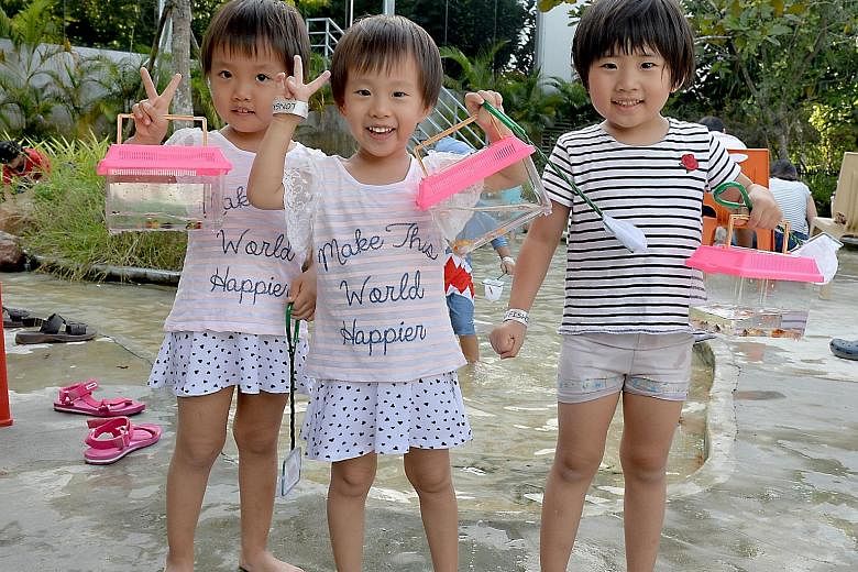 Far left: (From left) Zhang Mulai, Zhang Muqing and Chen Zhihan, all aged four, showing off their catch at Orto last Saturday. Left: Six-year-old Lynelle Lee fishing with her friends from Little Wonders Montessori Childcare at Fish @ Bugis+ last week