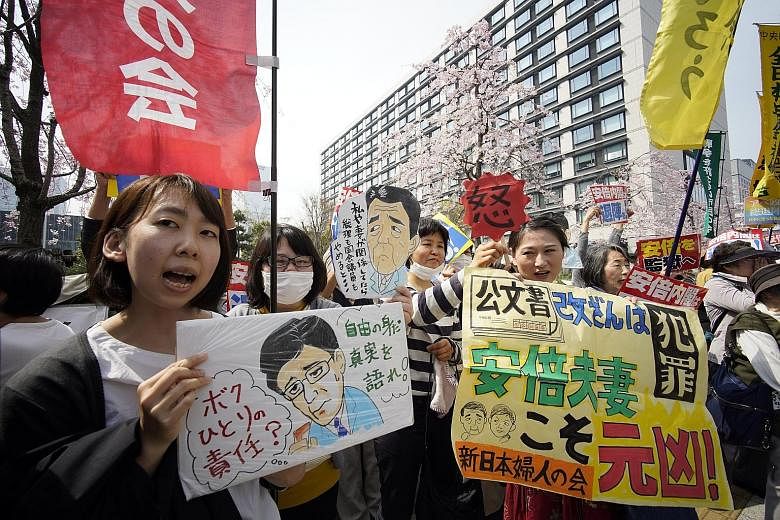 Protesters shouting slogans and waving placards outside the Diet in Tokyo yesterday. They called for Japanese Prime Minister Shinzo Abe and Finance Minister Taro Aso to step down over the land deal scandal.