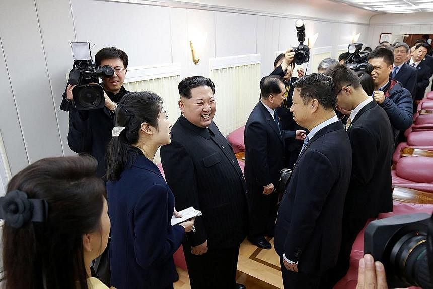 Mr Kim meeting Chinese officials inside a special train in an undisclosed location on Tuesday. The train he travelled in to Beijing was painted in drab green, and had 21 cars that were bulletproof. North Korean leader Kim Jong Un waving from his trai