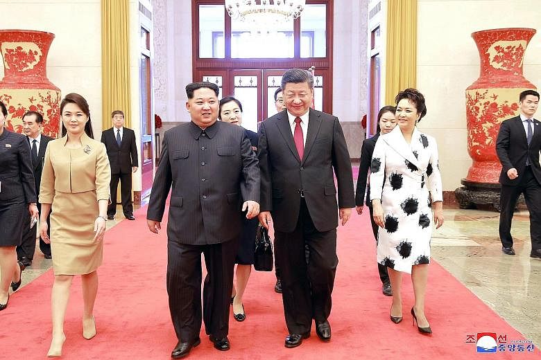 North Korean leader Kim Jong Un and his wife Ri Sol Ju with Chinese President Xi Jinping and his wife Peng Liyuan. The two leaders affirmed their countries' close ties and "traditional friendship" during Mr Kim's visit to Beijing.