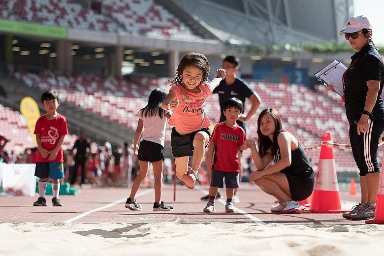 A little girl putting her best foot forward at the long jump pit during the Singapore Athletics Association's athletics team challenge and tug of war last Saturday. The event was part of the 12-day open house at the National Stadium, which attracted 